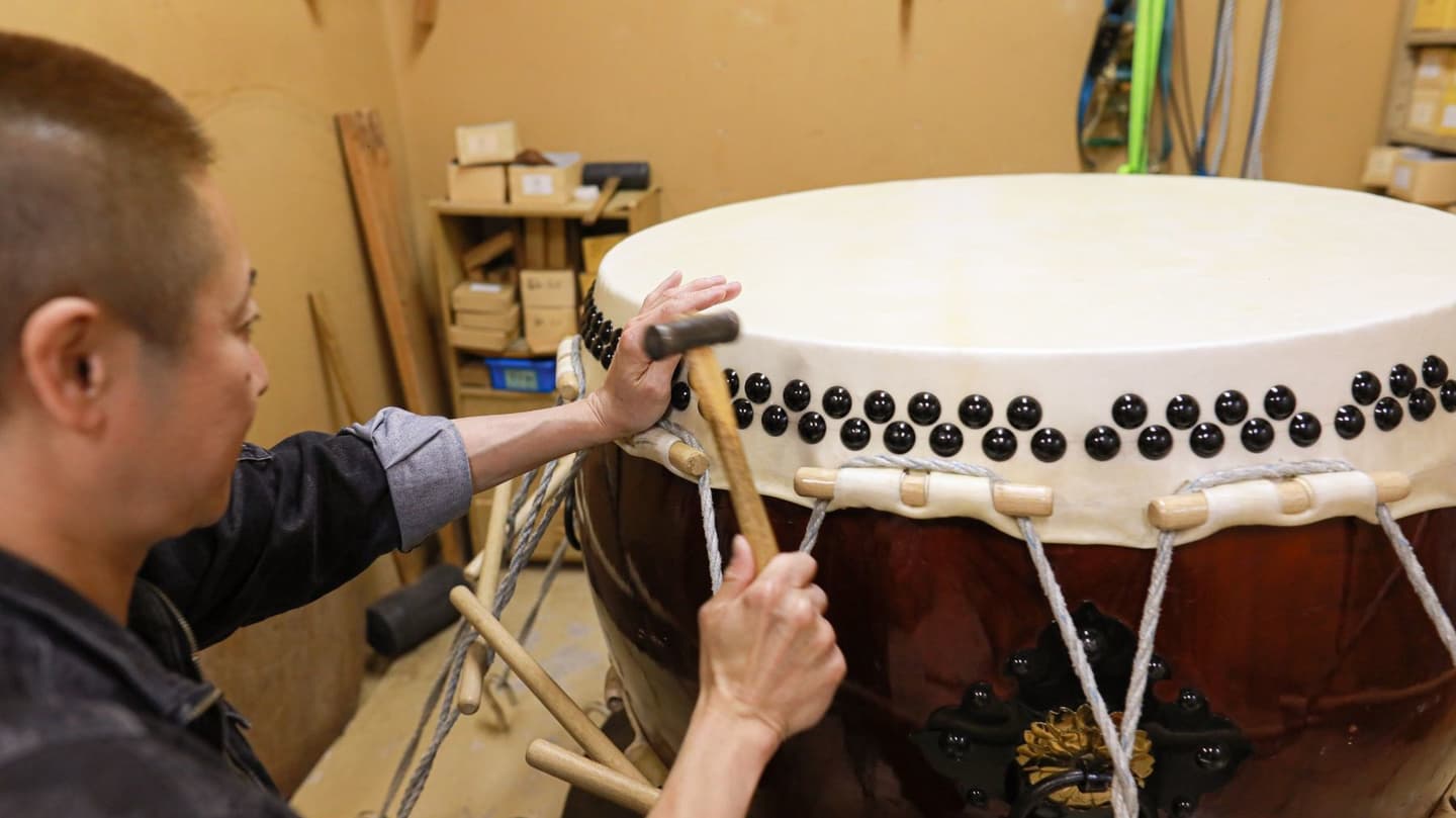 札幌の小路楽器店の工房で太鼓の革を張る職人。音を整え、命を吹き込む手しごと。